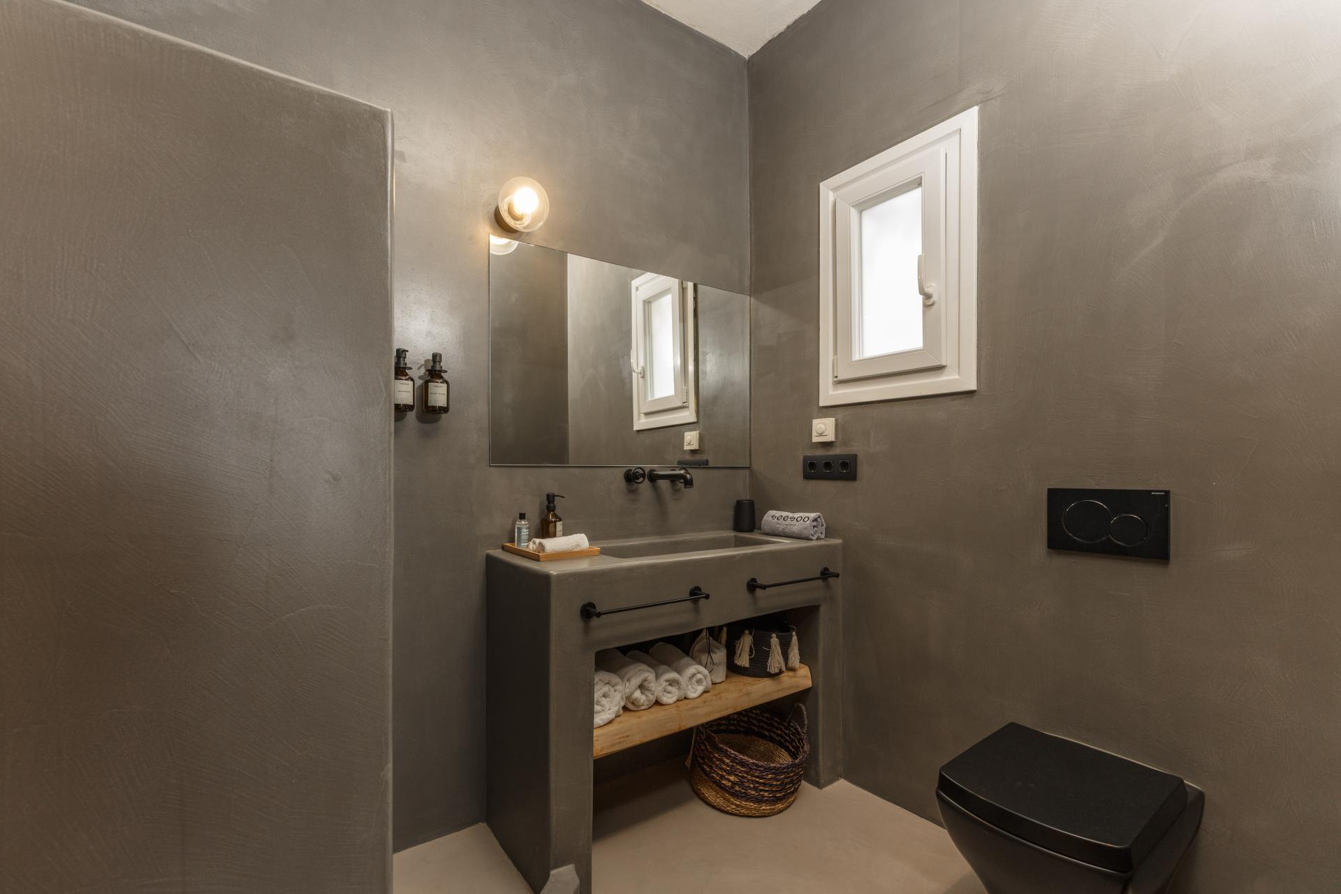Bathroom with grey walls and white towels under the sink